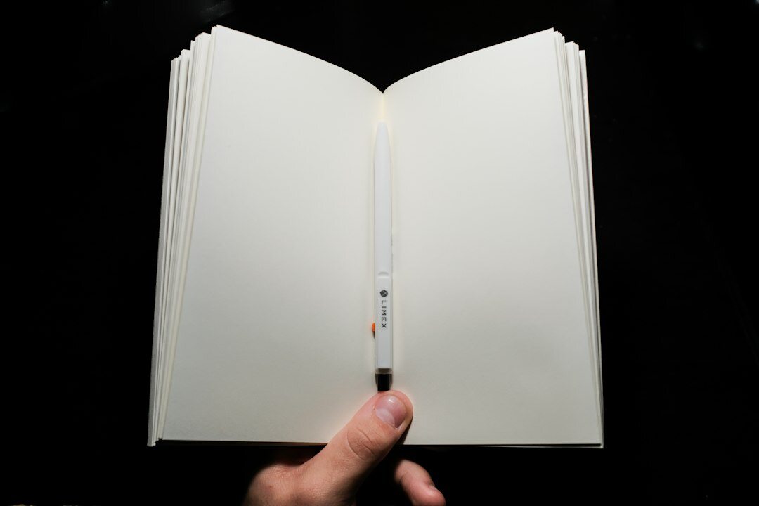 Close-up of a hand writing notes in a reporter notebook with a pen